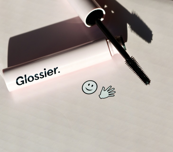Glossier Lash Slick Mascara flatlay open tube showing wand on pink background